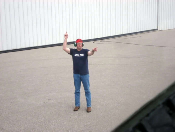 Todd “Pepe” Lemieux, a.k.a. “Farmboy”, points to Evans and signals engine start. Photo: Dave O'Malley