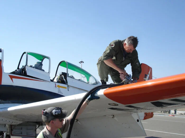 Evans pumps 100 Low Lead into the wing tanks at Regina. Photo: Dave O'Malley
