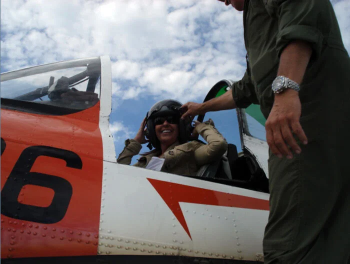 Beautiful airplanes attract beautiful women... it's a law of the universe. Here Sudbury FBO operator Christine Romansky checks out the T-28. Christine runs the Northern Aviation Services Shell FBO at the airport. Photo Dave O'Malley