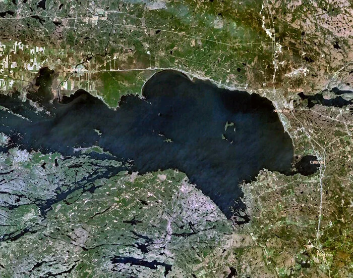 File this under “I never knew that!” A satellite shot of Lake Nipissing reveals the remains of two “deep-origin” volcanoes. The island archipelago on the middle of the lake, known as the Manitou Islands and the circular bay at the eastern end of the lake, known as Callander Bay were formed by eruptions from farther below the earth's surface than ordinary volcanoes. These bring near the surface some of the rarest minerals known to man... thus sating the world's appetite for apatite!