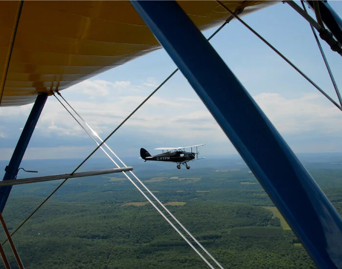 Eric Dumigan frames C-FYPM in the struts and bracing of a Stearman biplane. Though not as spectacular as the rugged landscapes of the Congo or New Zealand, it’s still beautiful flying country. Photo: Eric Dumigan
