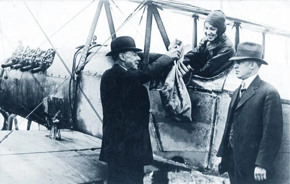 In 1918, Katherine Stinson, sitting in her Curtiss Special, receives the mail (259 letters) from Calgary postmaster George King, accompanied by the manager of the Calgary Industrial Exhibition, Ernest Richardson, at right. Archive photo.