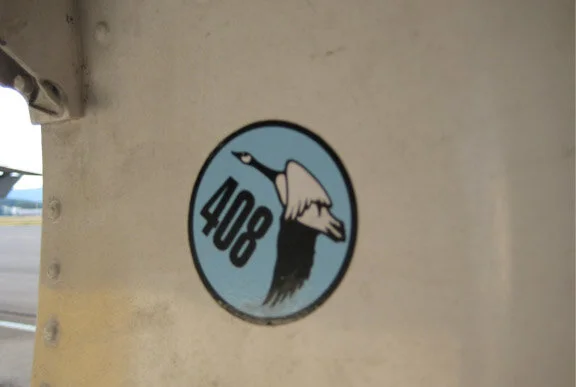 Visiting squadrons delight in zapping another squadron’s aircraft where it will not be noticed until it gets home. Here, 408 Squadron CAF, a helo unit, sticks it to the fighter boys inside the gear door of a CF-18. Photo by WireLizard at Flickr.com