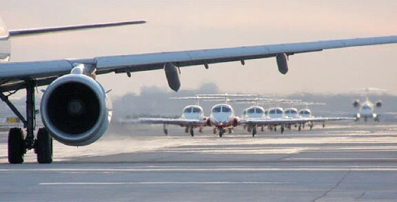 On Grey Cup Sunday, the Snowbirds line up on the taxiway between outgoing flights as they prepare to make a gorgeous, smoke-trailing flypast of the Grey Cup festivities outside the SkyDome stadium in Toronto. Photo by Rob Piercy a.k.a. Contrails on Flickr