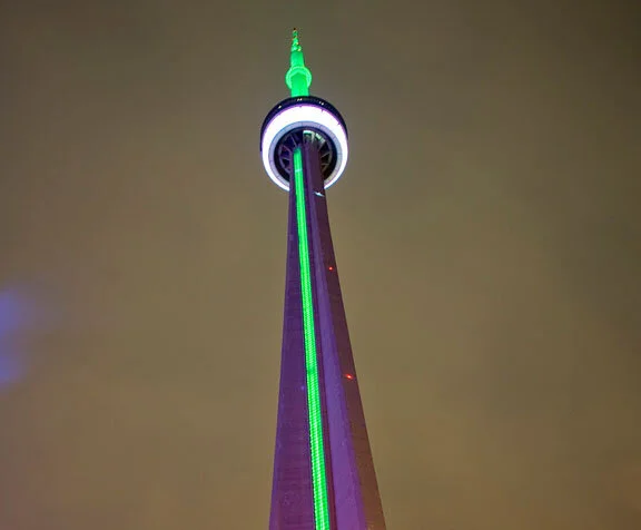 After the game was concluded, the same CN Tower that Mitchell had brought his team past earlier in the day is lit with green and white lights in honour of their win. Photo by sjgardiner at flickr.com