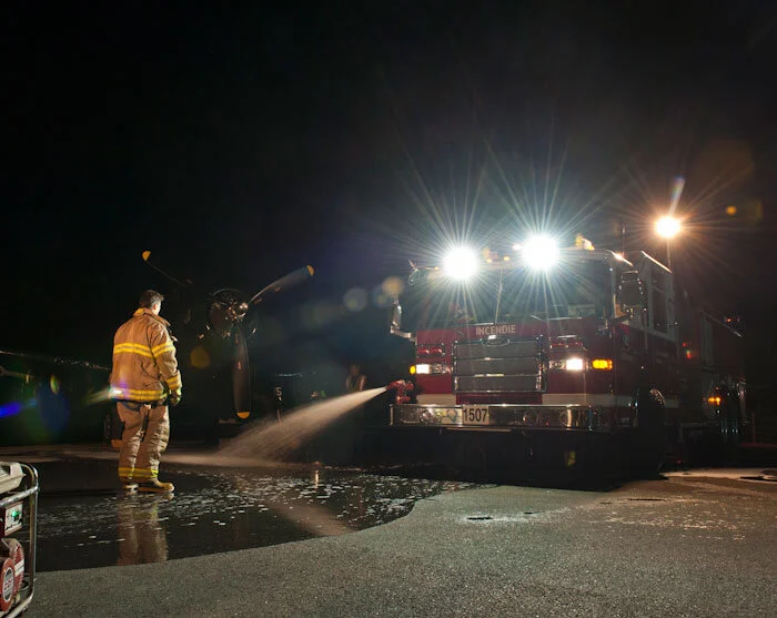 Firefighters of La Ville de Gatineau were essential in giving the photo shoot some depth. The city generously provided a pumper truck and crew to spread a thin reflective pool of water on the ramp surface. Organizer Allnutt had predicted that the pool would evaporate rapidly, so haste was made to start the shoot immediately after the dousing. However, the cool late-summer evening prevented the prediction form coming to pass and the pool of water stayed right where it was needed during the shooting. Photo: Peter Handley