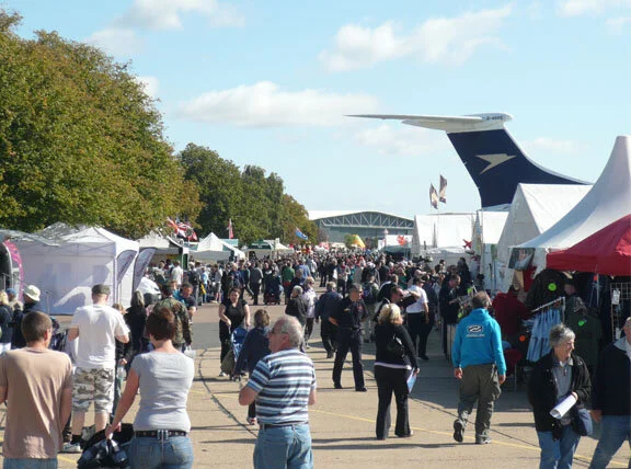 Gates opened at 9 AM at Duxford. This was the scene at 930 AM. The popularity of Duxford events is such that people stream in the gates from the get-go. The "main drag" at Duxford features scores of hobby shops, aviation art galleries, binocular and camera merchants, full motion flight simulators and booths for related aviation restoration groups. Flying displays did not start until 2 PM, so retailers did brisk business all day. Photo: Dave O'Malley