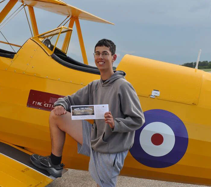 Matthew Taylor, a 16-year-old Flight Sergeant at 702 “Lynx” Royal Canadian Air Cadet Squadron in Saskatoon, Saskatchewan holds his boarding pass, confirming he is good to go aloft for a trip back in time over the Penhold gliding base near Red Deer. Matthew said, “The fact that I was chosen for such a unique opportunity was a great honour, and I hope that this once-in-a-lifetime chance will be available to many more Cadets in the future. Upon completion of high school, I want to go to university and eventually become an Aerospace Engineer with the Canadian Forces. I would like to thank all the generous sponsors and donors for the amazing opportunity they have provided. That thanks would be on behalf of all cadets who got to take part of the great opportunity.” Photo: Yellow Wings Stearman Team