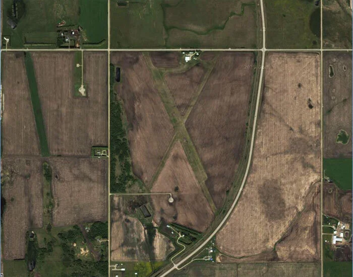 A satellite view of Netook today. Netook, the municipal airport for the small Alberta farming community of Olds, is located 4 miles north of the town. The airport is owned and operated by the Air Cadet League of Canada – Alberta Provincial Committee. It is home to the Netook Gliding Centre, one of five Air Cadet Gliding Program locations in Alberta. During the Second World War, Netook was a Relief Landing Field for No. 32 Elementary Flying Training School (EFTS) at Bowden, outside Calgary. As such, it was designed to take aircraft practising circuits and forced landings and thereby relieve the traffic at Bowden on busy days. It features two intersecting grass strips of good length—Runway 01–19 (3,700 ft) and Runway 14–32 (4,400 ft). Image via Google Maps