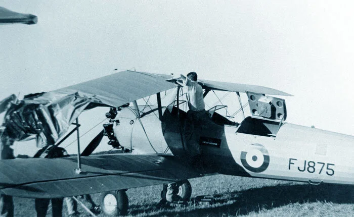 The Warrant Officer Harry Hannah Boeing PT-27 Stearman is in fact one of the original group of 300 Stearman aircraft acquired for the British Commonwealth Air Training plan and assigned specifically to elementary flying training of only RAF student pilots and only in Alberta. Today, she is in pristine condition, having been returned to Boeing in the United States after several months along with all 300 Stearmen BCATP aircraft, which were deemed inadequate for flight training in an Alberta winter. During its training career at No. 32 EFTS, our Stearman (RCAF s/n FJ875) was involved in a ground taxiing accident with another PT-27 Kaydet at Netook Relief Field, with both aircraft suffering serious damage to their wings. Here we see mechanics from Bowden, sent to bring back the damaged airframes, removing the upper port wing of FJ875 on the grass at Netook. Photo via Clarence Simonsen