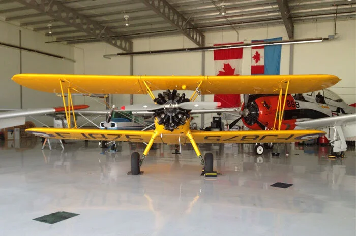 Back in the barn for a little down time, the Harry Hannah Boeing Stearman has done yeoman service at flying through the Rockies to Victoria on Vancouver Island and then back again to Red Deer and the former BCATP base at Penhold. Photo: Yellow Wings Stearman Team