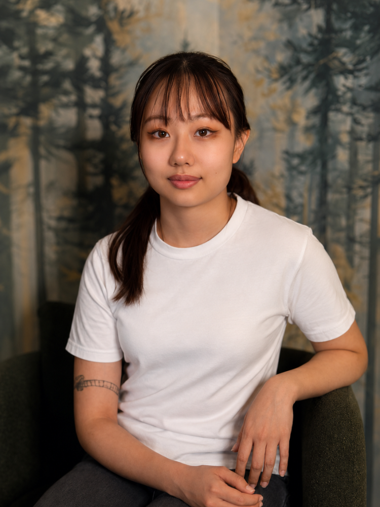 Smiling woman with brown hair wearing a white shirt indoors