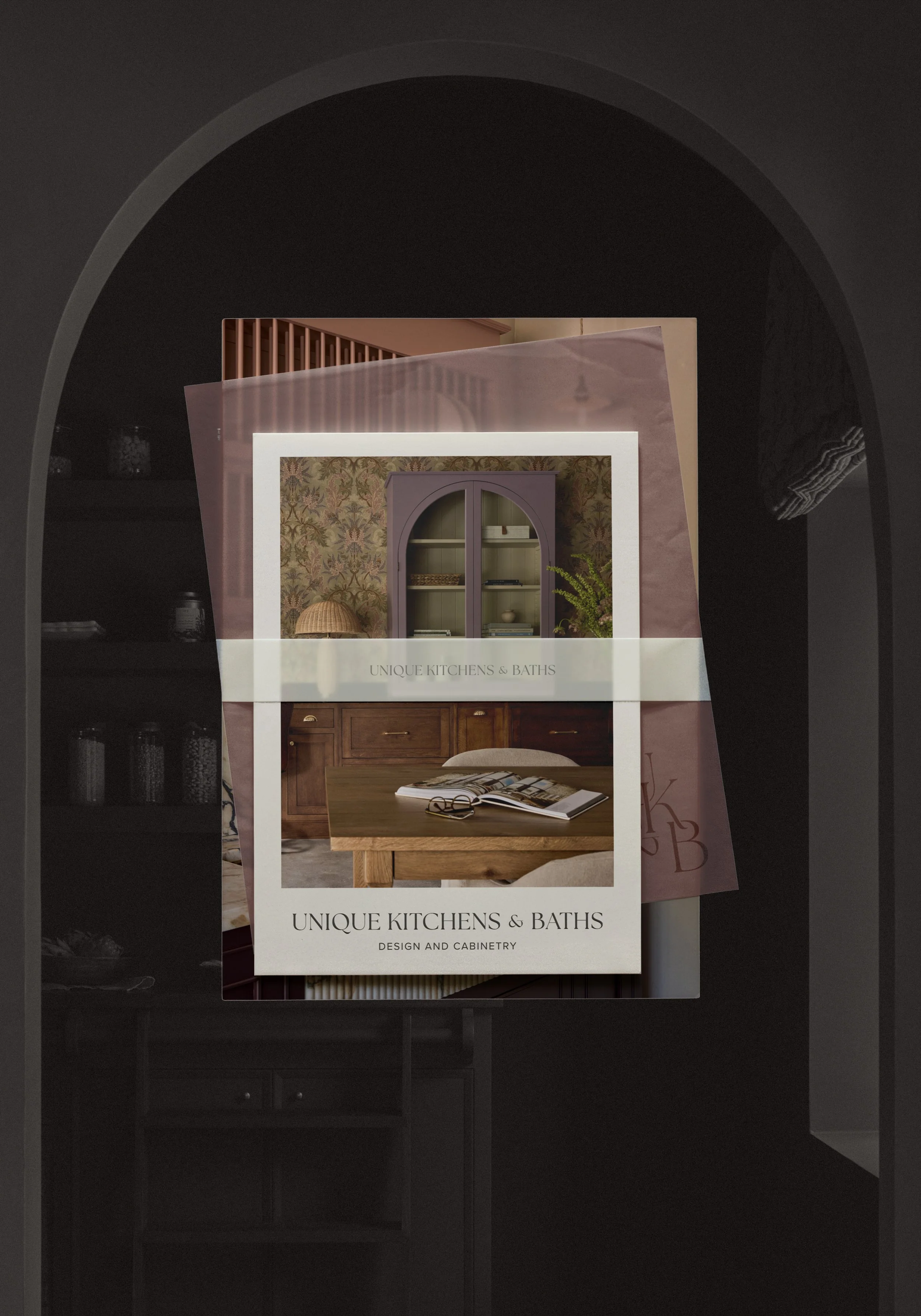 A stack of interior design catalogs featuring kitchens and baths, displayed in a dark archway with black walls.