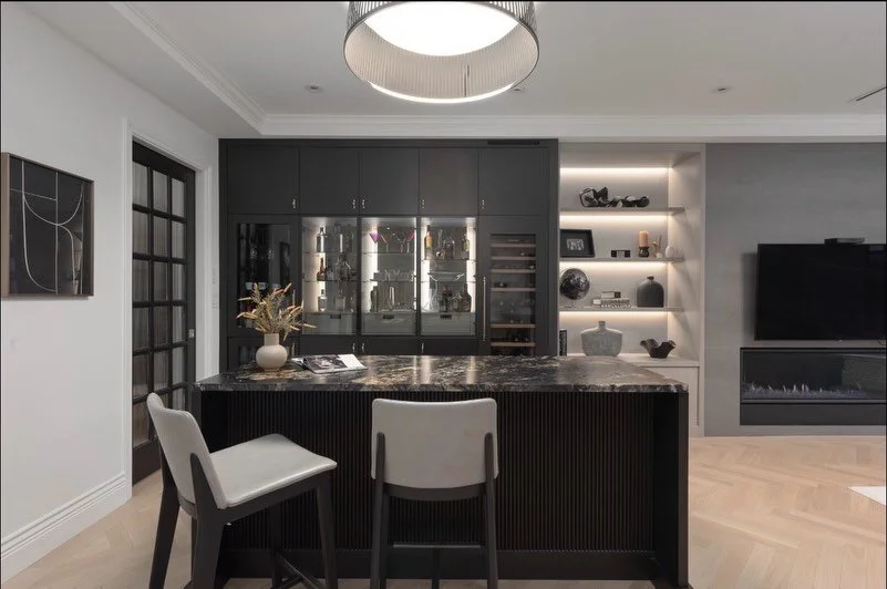Where luxury meets togetherness.
Thoughtfully positioned between the kitchen and family room, this bespoke bar is designed for effortless hosting and everyday moments alike. Warm finishes, softly integrated lighting, and custom millwork create a spac