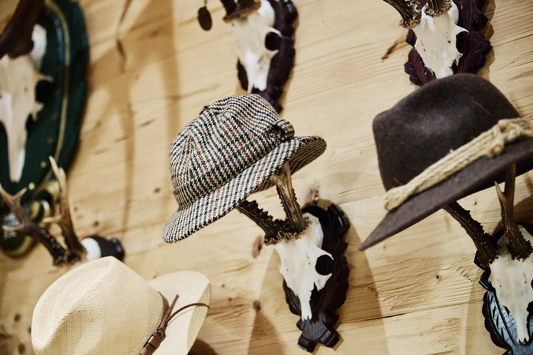 Neu angeordnete Sammlung von Jagdtrophäen und Hüten als Teil der Wandgestaltung im Gartenappartement.