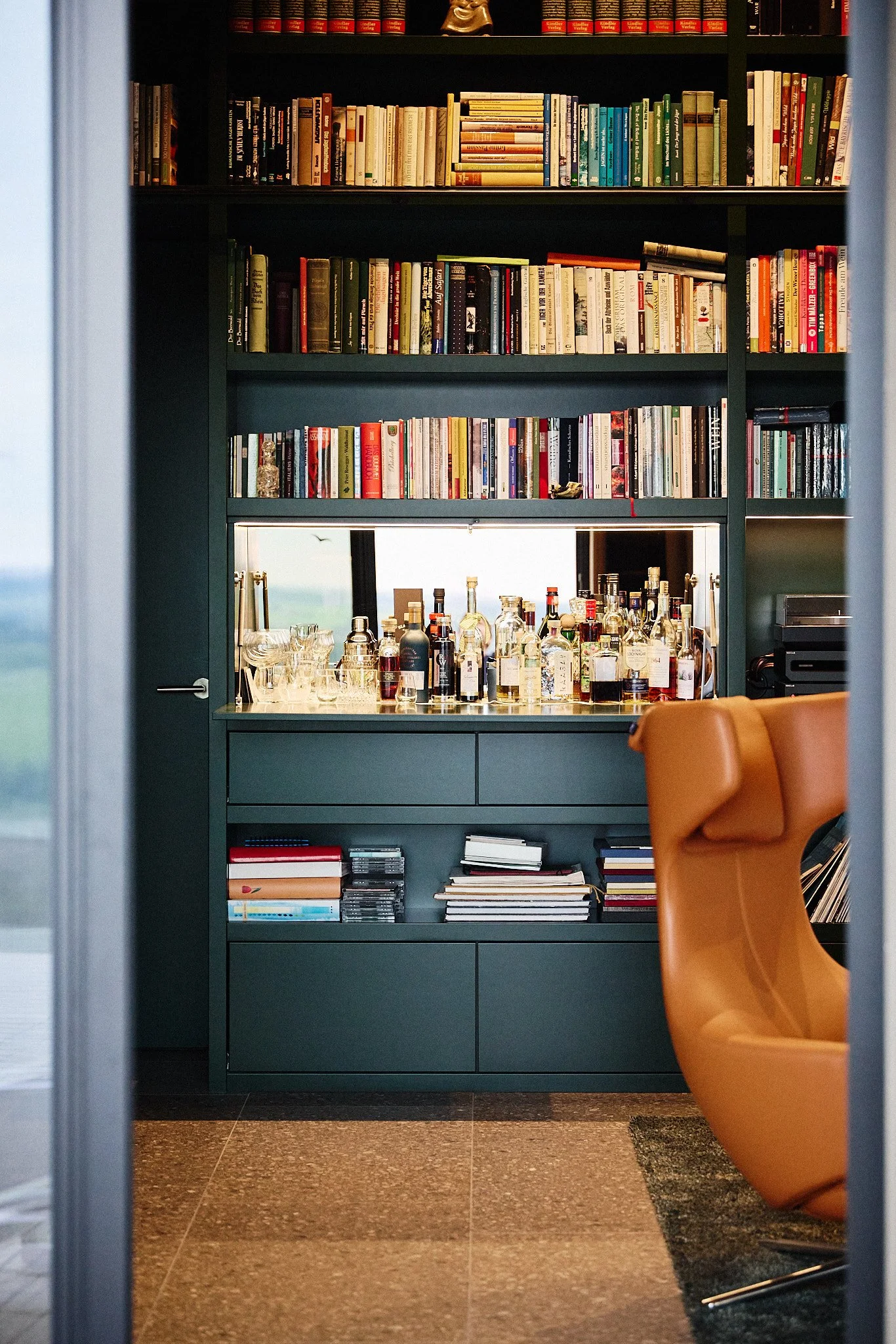 Maßgefertigte dunkelgrüne Bibliothek mit integrierter Bar, Stauraum für Bücher und Schallplatten im Wohnbereich.