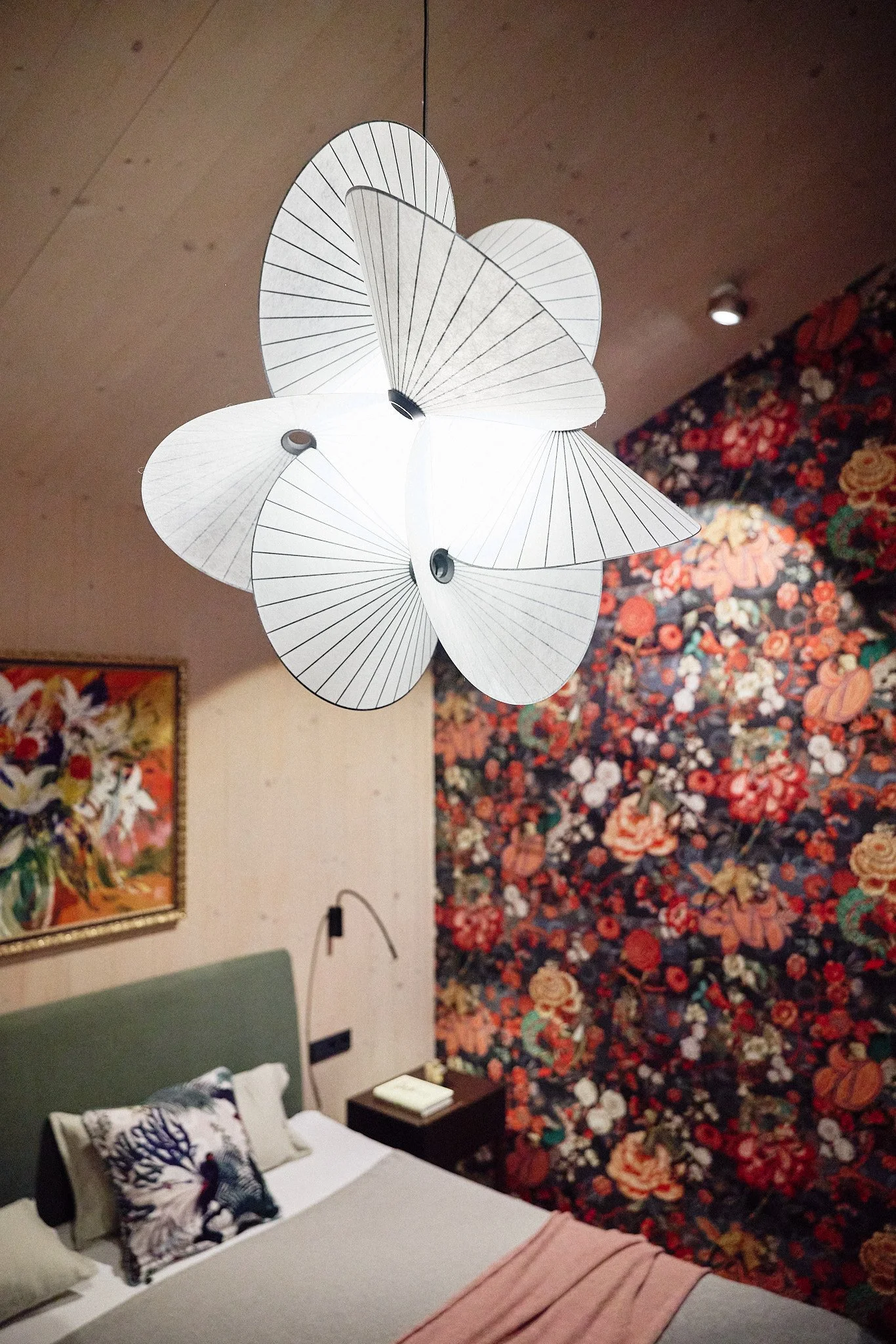 chlafzimmer im Architektenhaus am See mit floraler Wandgestaltung, Kunst, Polsterbett und skulpturaler Pendelleuchte.