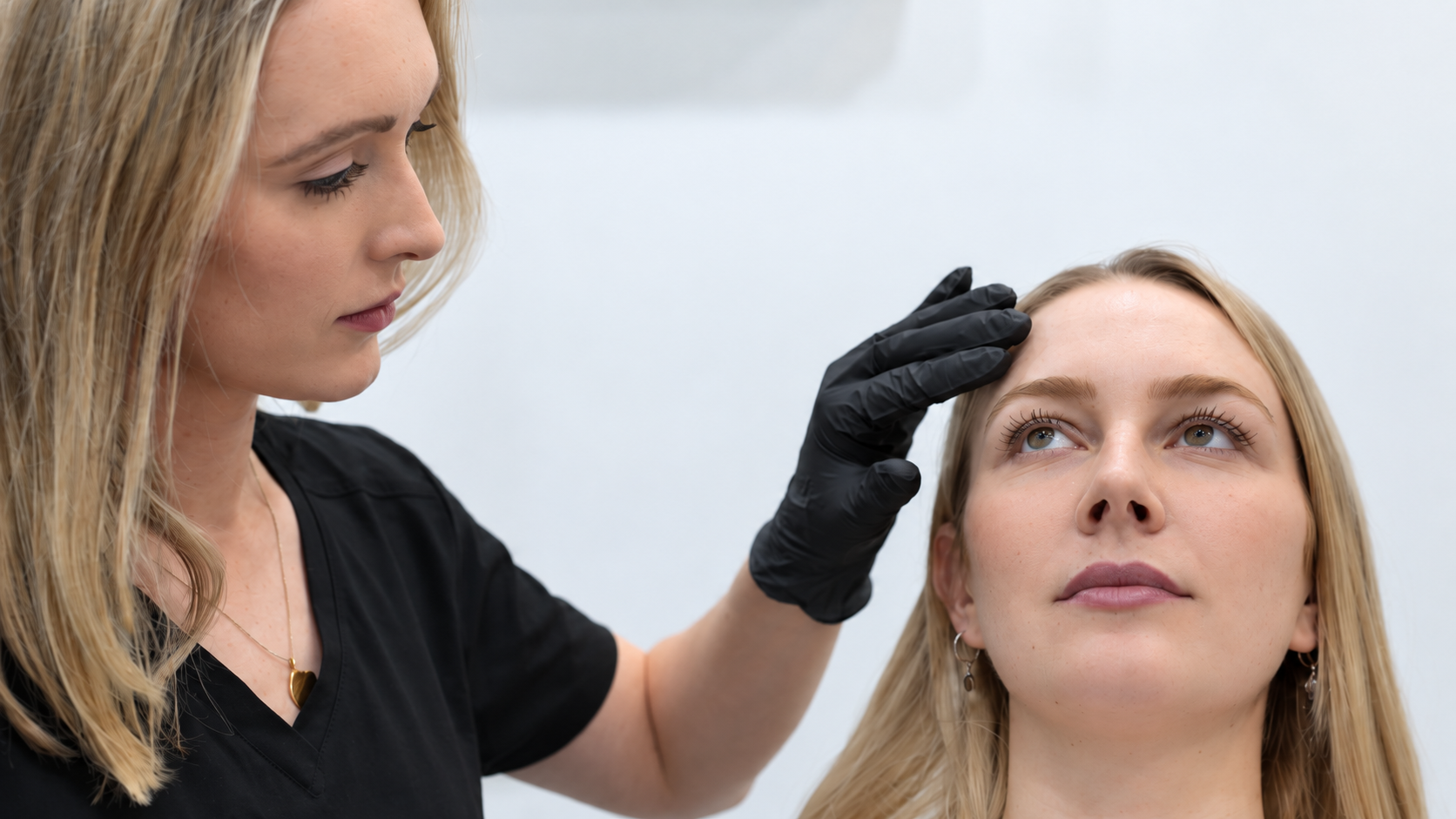 Dr Kate Bennett-Brown assessing a patient’s under-eye area during a consultation at her London aesthetic clinic