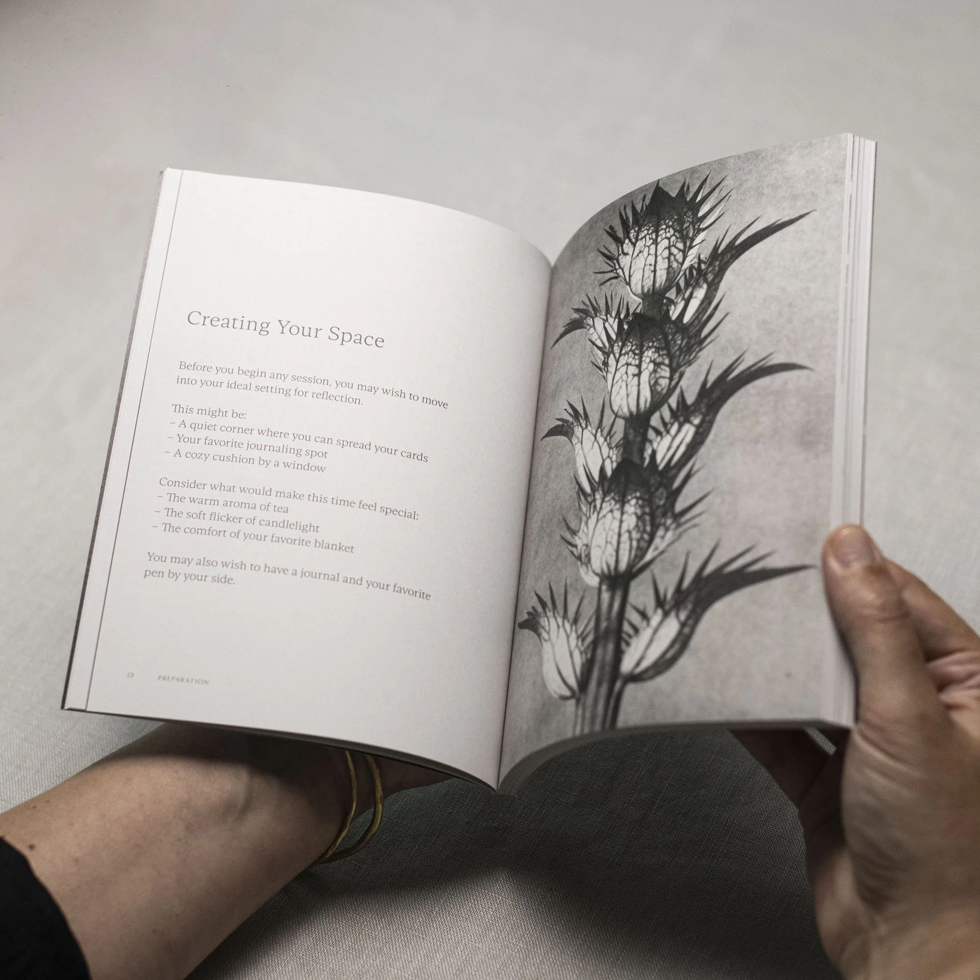 Hands holding ENVISAGE guidebook open to page with recommendations for creating your space