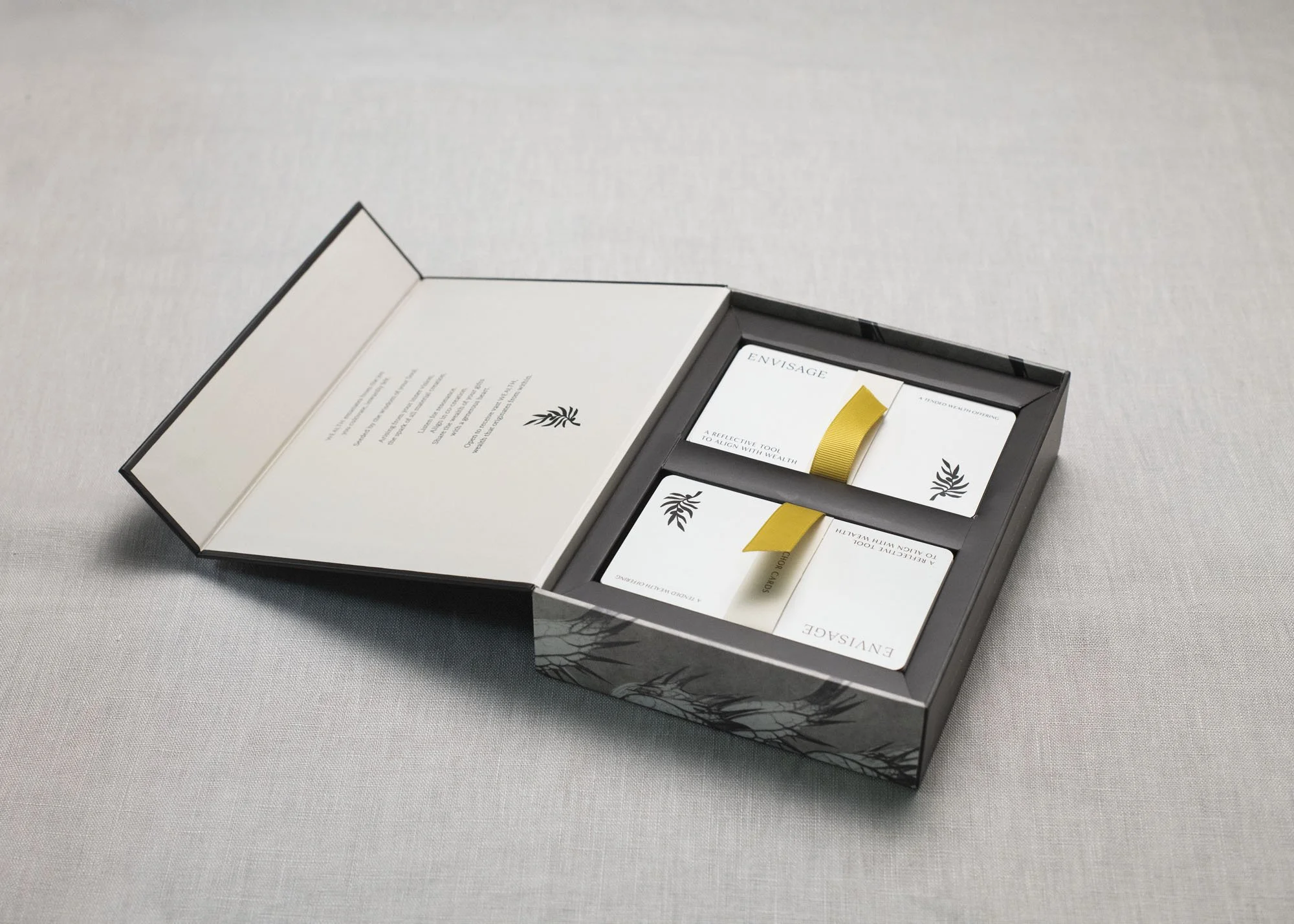 ENVISAGE opened displaying two stacks of cards, nestled in box with gold ribbon