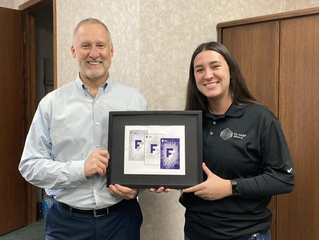 Katie Slick presenting her selected Fort Financial card designs alongside a Fort Financial representative in 2022.