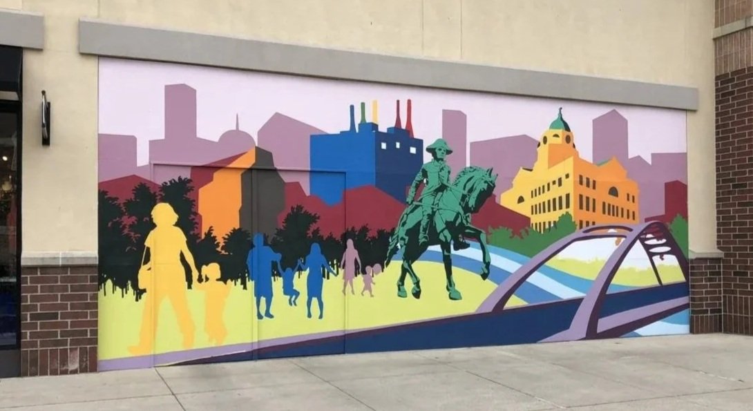 Colorful public mural at Jefferson Pointe in Fort Wayne featuring local architecture, landmarks, community silhouettes, and the General Anthony Wayne statue.