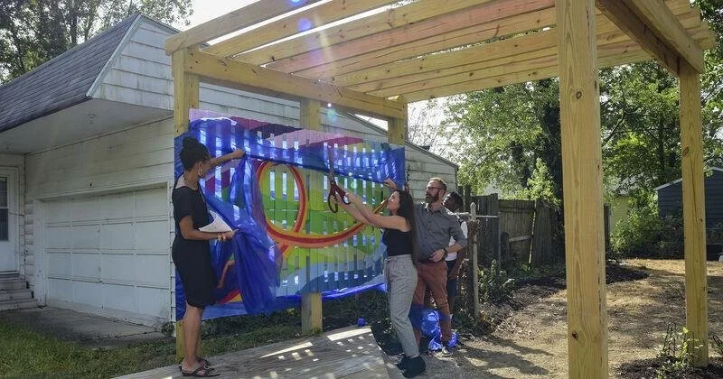 Ribbon-cutting ceremony at the 2019 opening of The Harbor in Fort Wayne with Katie Slick and others in front of the completed community mural.