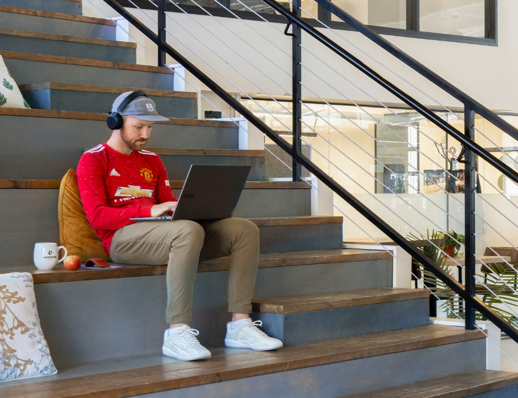Man sitting on bleachers with laptop