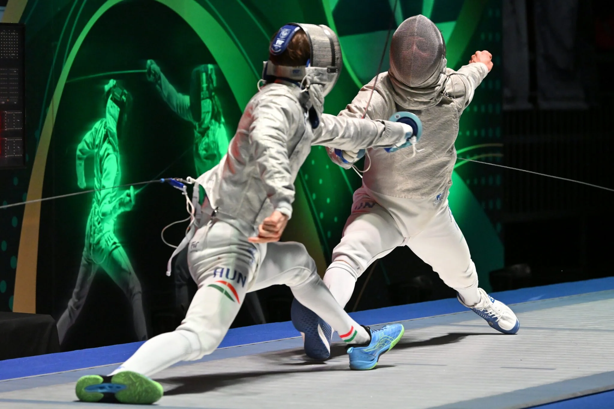 Two fencers in white protective gear engaged in a match, with one lunging at the other on a fencing strip, and a green neon graphic background.