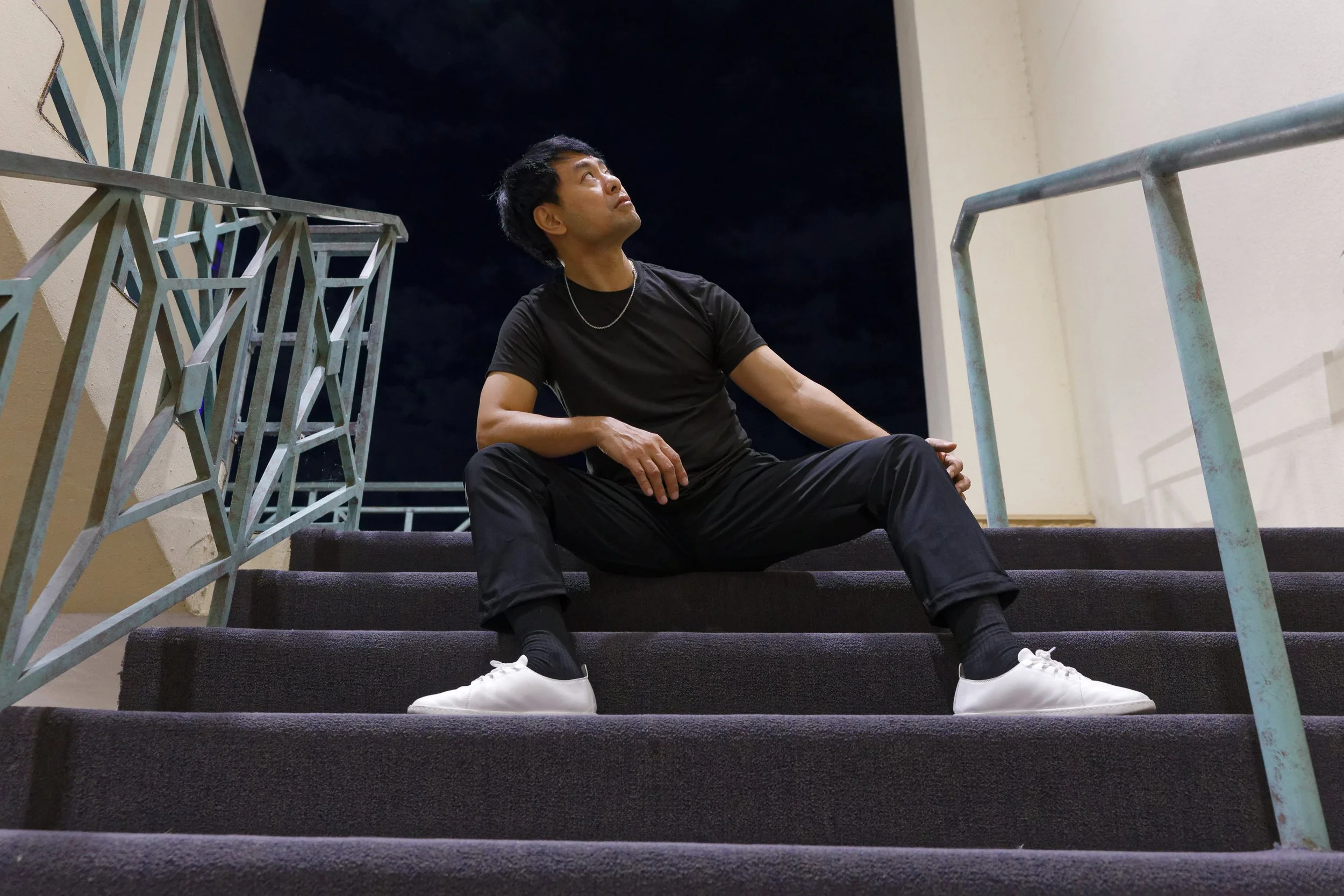 Randell sitting in a stairwell and looking into the distance
