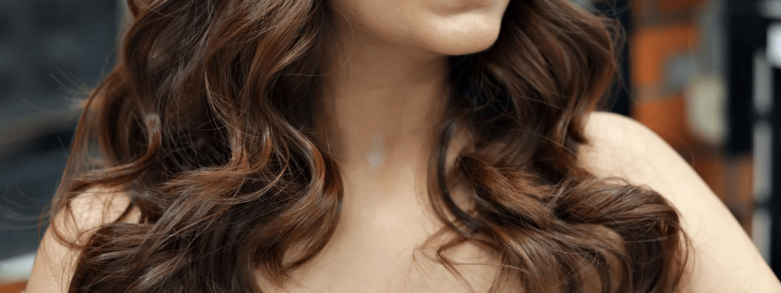 Woman with long, healthy wavy hair after a Portland Oregon hair extensions service at Penelope Hair Salon