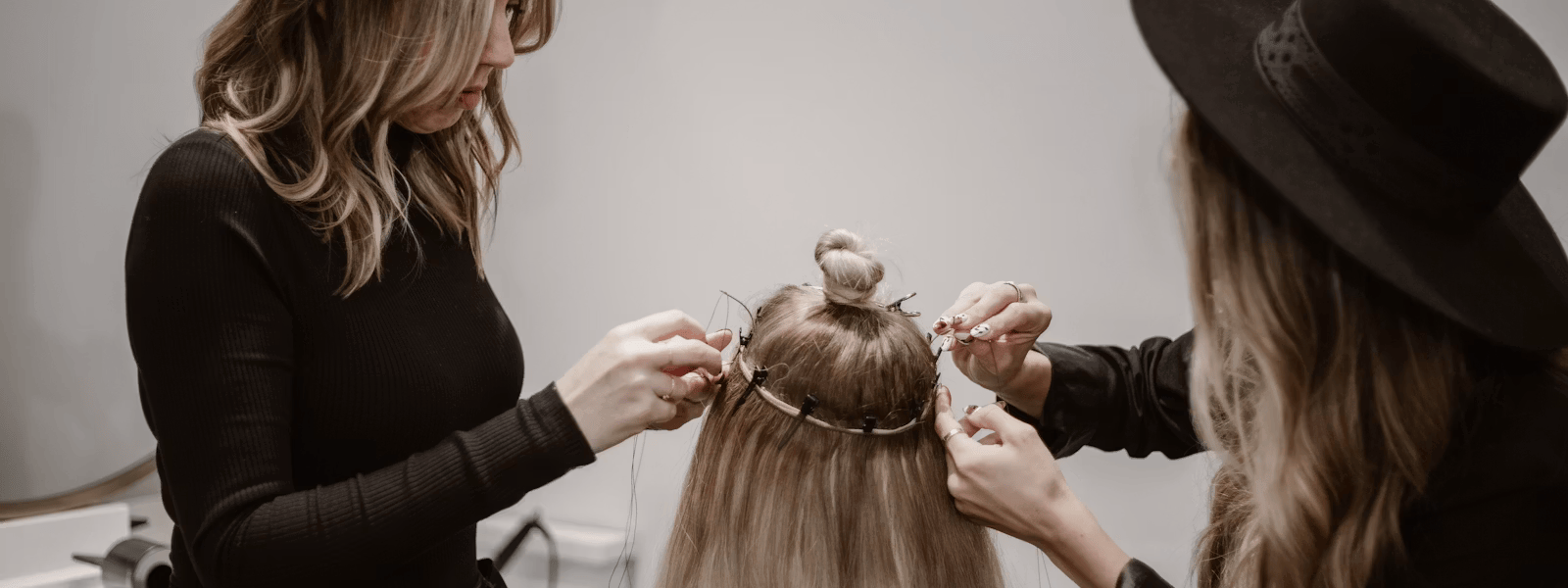 Stylist applying natural hair extensions to a client at a Portland Oregon salon