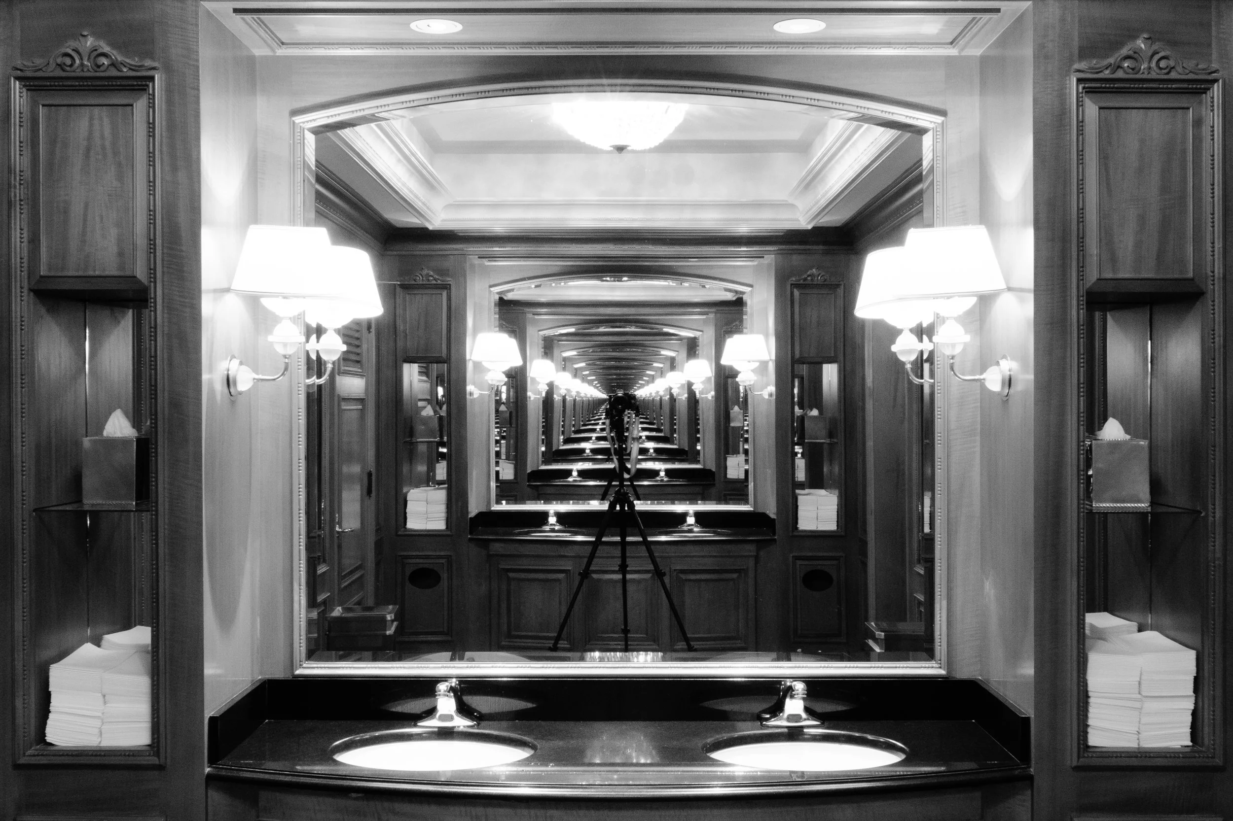 Woman in green dress kneeling with bouquet of yellow flowers on fire, beside a pink newspaper box decorated with sunflowers.