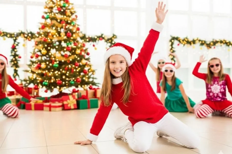 Children in Christmas outfits in a dance class in front of a decorated Christmas tree during a festive kids party activity.