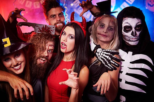 A group of adults dressed in Halloween costumes posing playfully at a themed party, representing fun Halloween activities and group entertainment for adults in London.