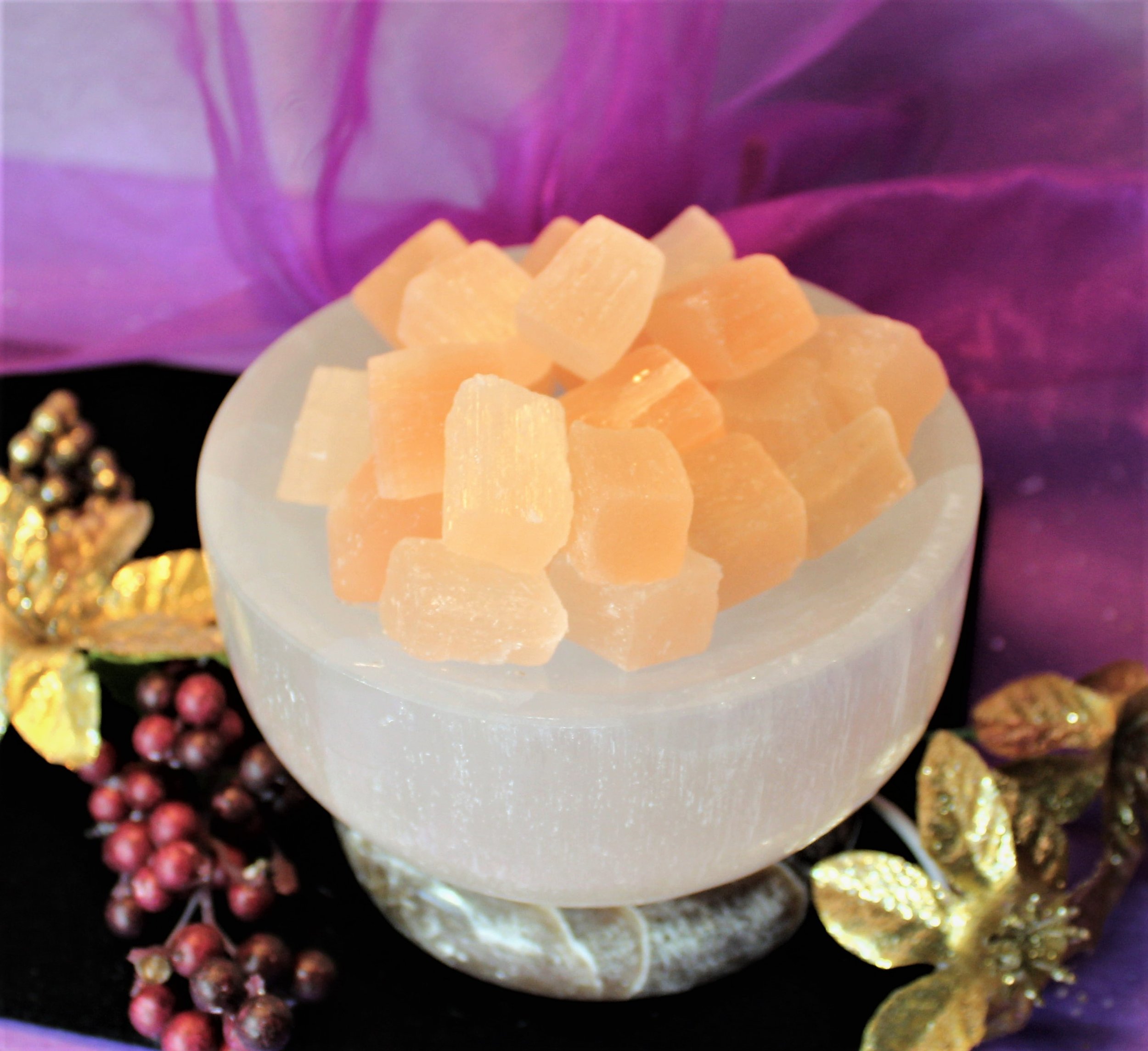 "White Selenite Bowl, glowing with peach selenite cubes on an onyx base. Creates a serene, ethereal light, perfect for meditation and elevating spiritual surroundings.
