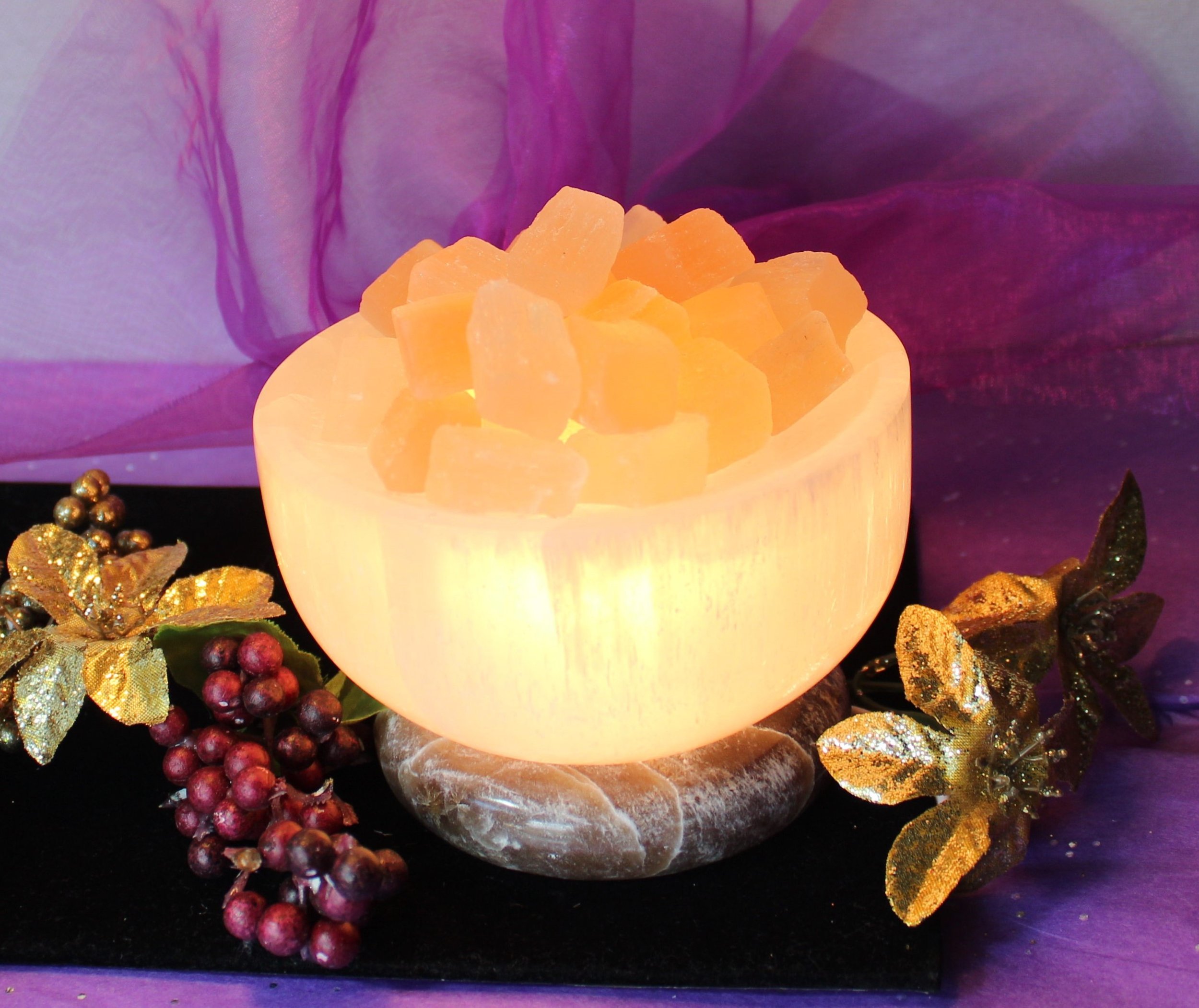 White Selenite Bowl with luminous peach cubes on an onyx base. This captivating piece creates a peaceful, angelic atmosphere, perfect for enhancing spiritual energy