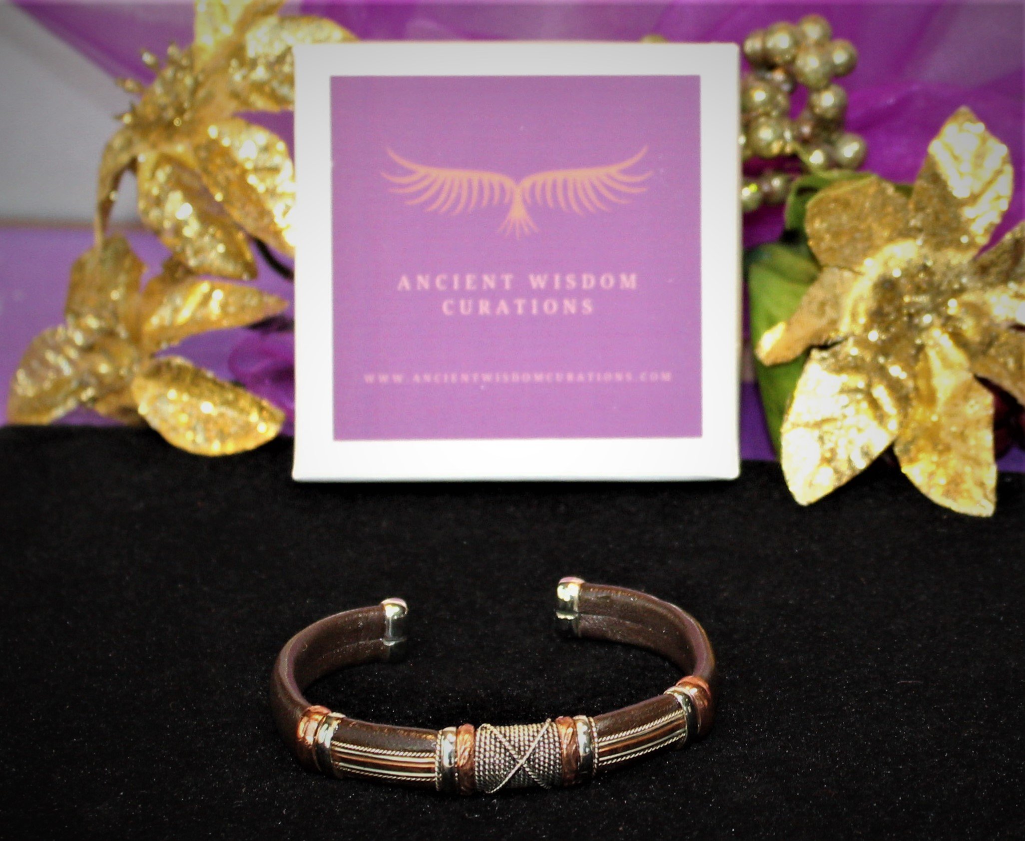 Artisan-made brown leather cuff bracelet featuring a cross-hatched and parallel band design with varied colored coppers—elegant and durable, perfect for any occasion.