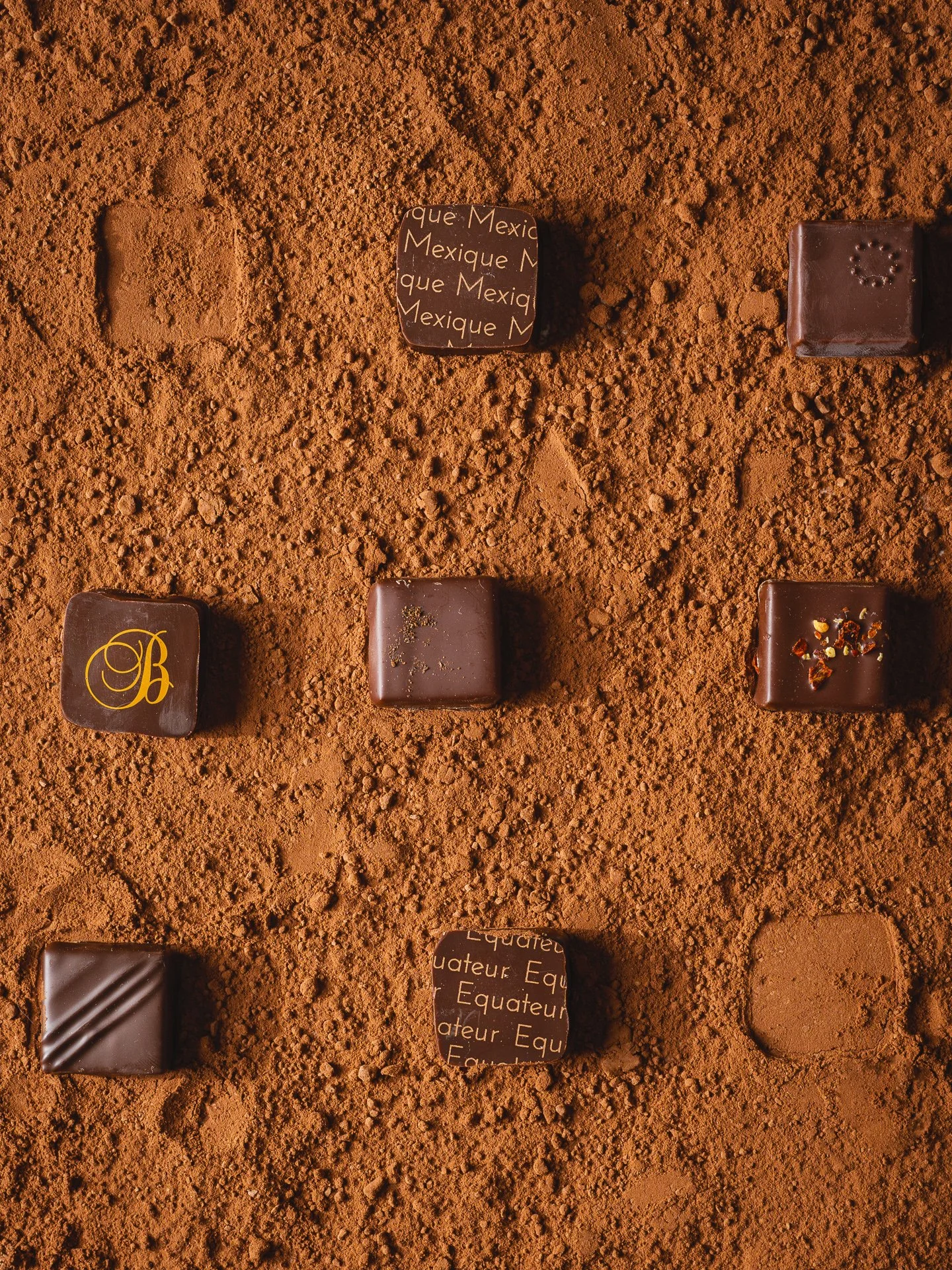 Tablette de chocolat sur un fond de cacao en poudre, avec différentes inscriptions et décorations