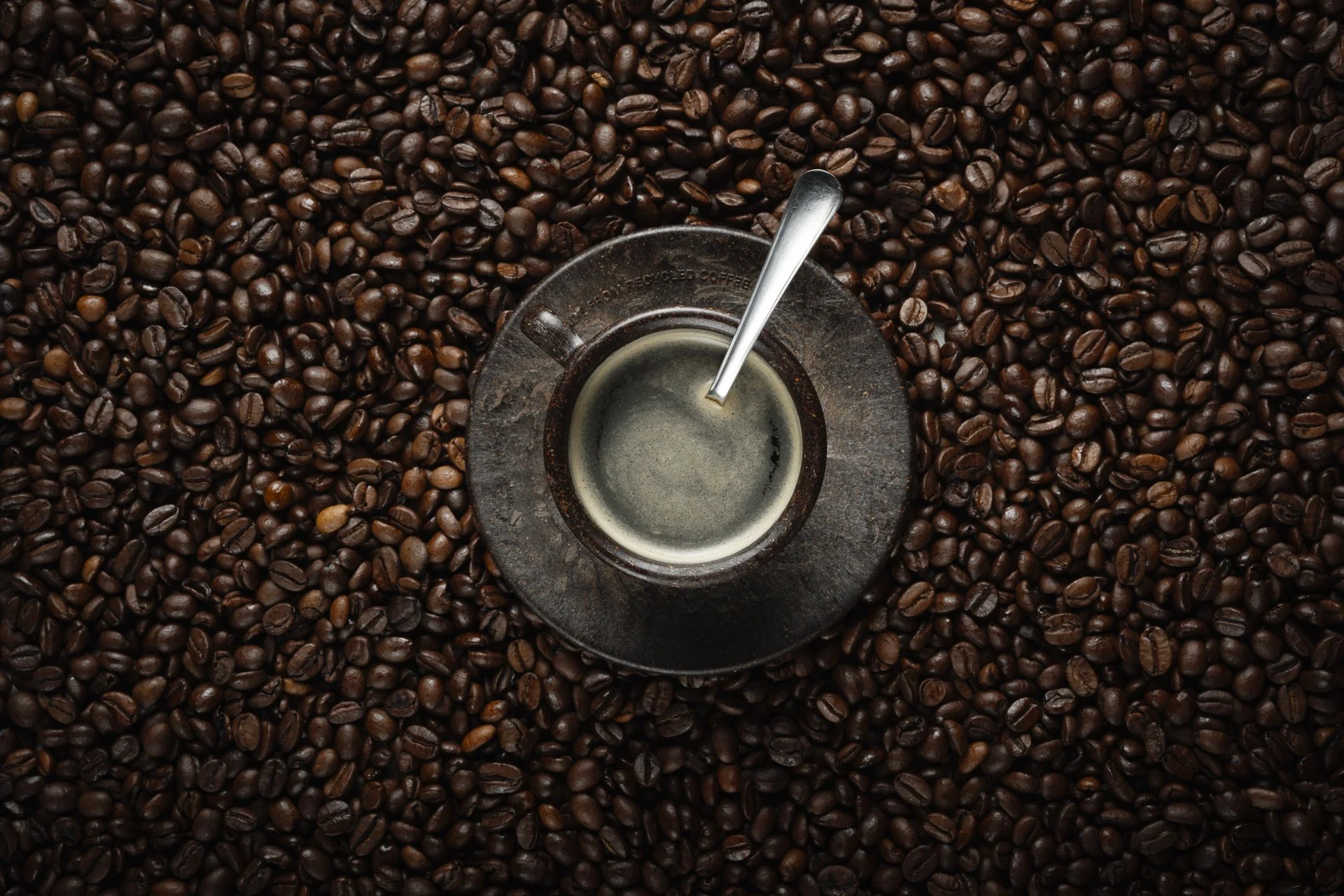 Une tasse de café écrasé sur un fond de grains de café.