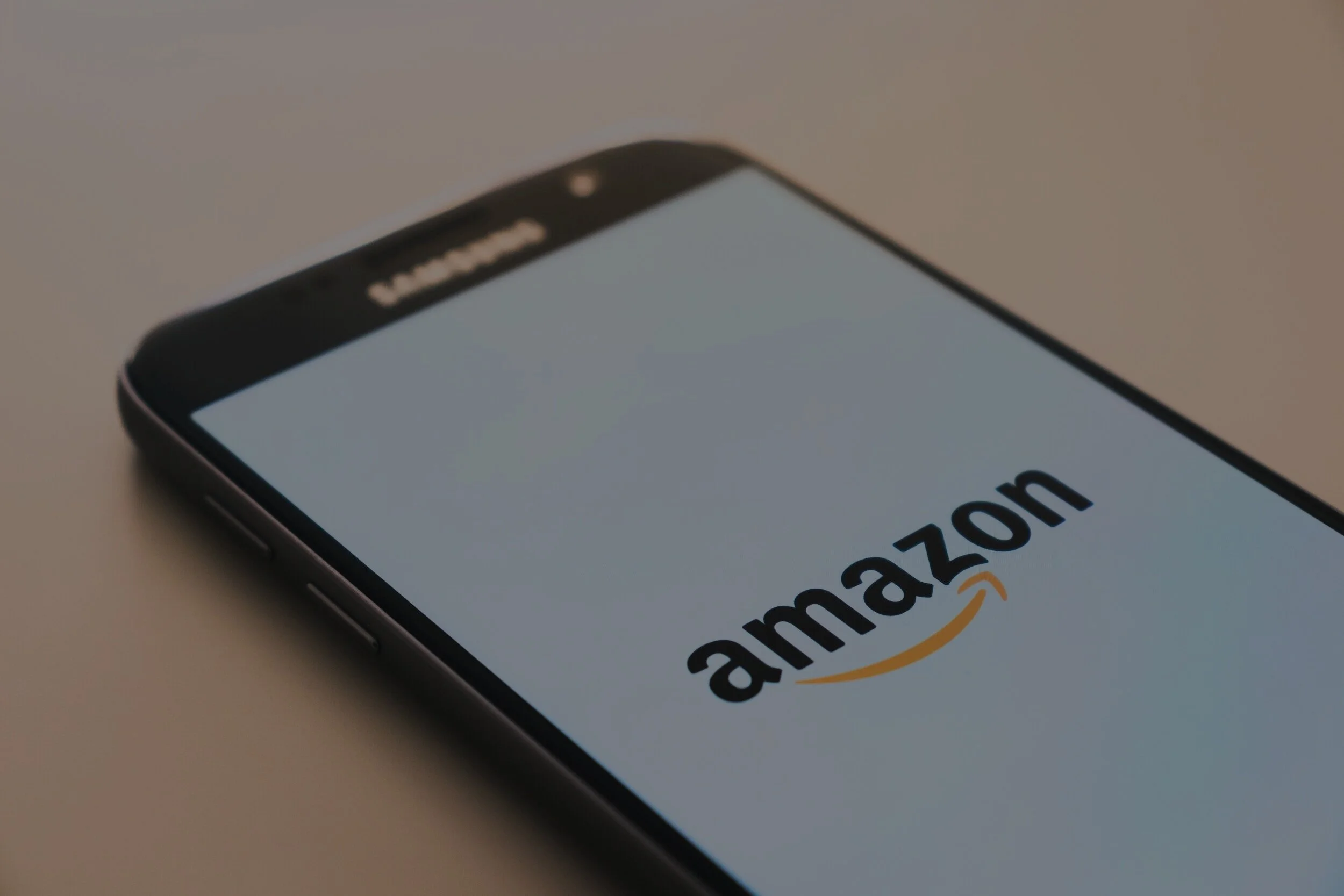 Picture displaying a smartphone with the Amazon logo on the screen.