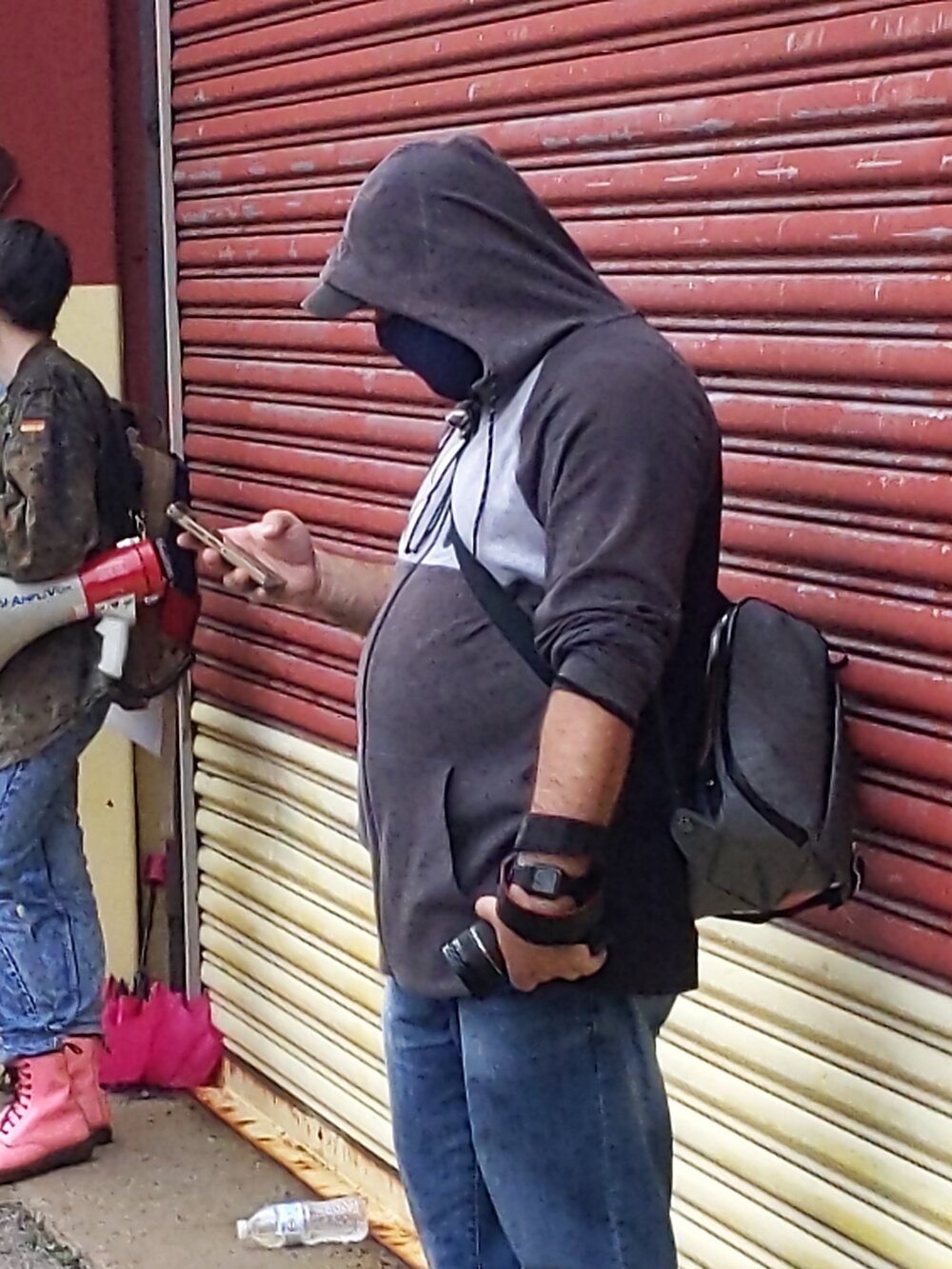  A plainclothes NYPD officer photographs protestors during an action in Brooklyn. 