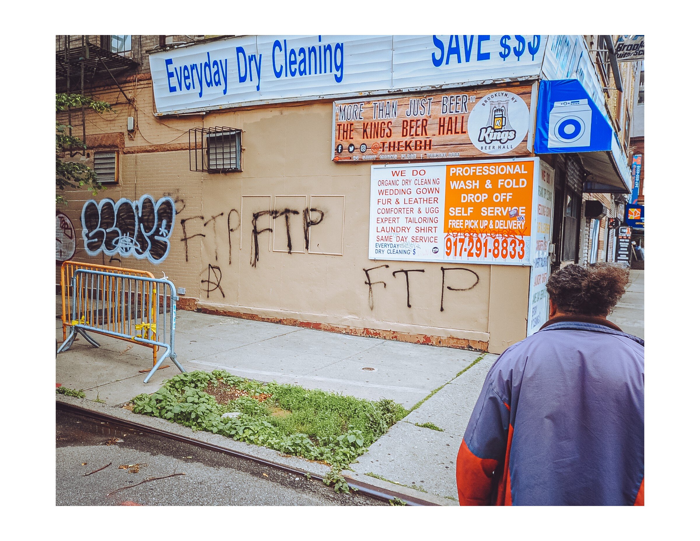 A person looks at graffiti put up after a night of protesting and rioting in Brooklyn. 