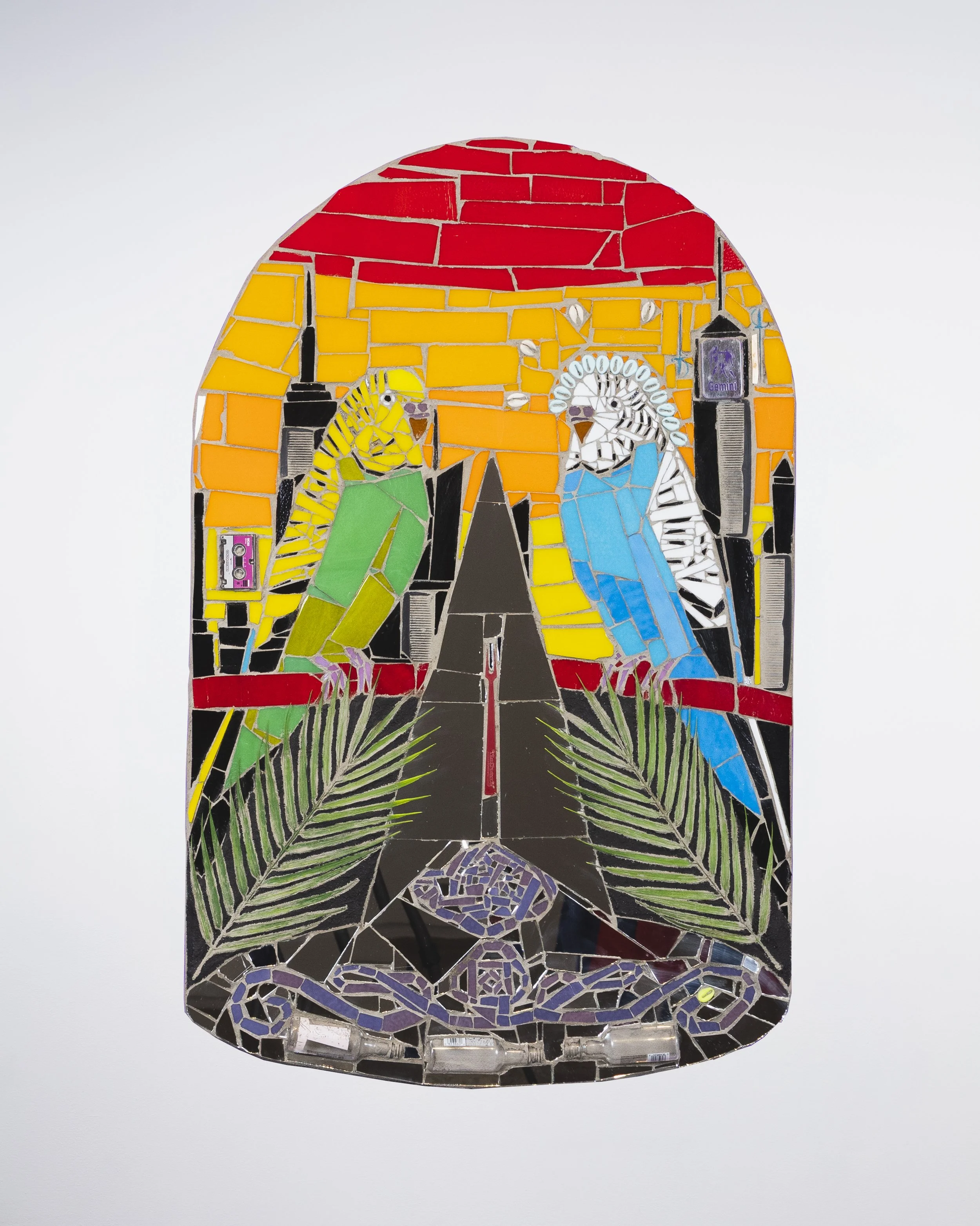 Marco DaSilva, "Blue Gemini / Gêmeos Azul," 2025, Nathan's french fry fork, plastic palms, miniature liquor bottles, micro cassette, combs, cowry shell, plastic cowry shell, mosaic glass, mirror and mortar on compressed foam board, 22 × 34.5 in.