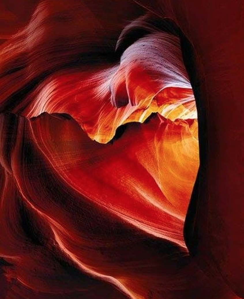 Abstract image of a canyon with swirling red and orange rock formations creating a heart-shaped outline.