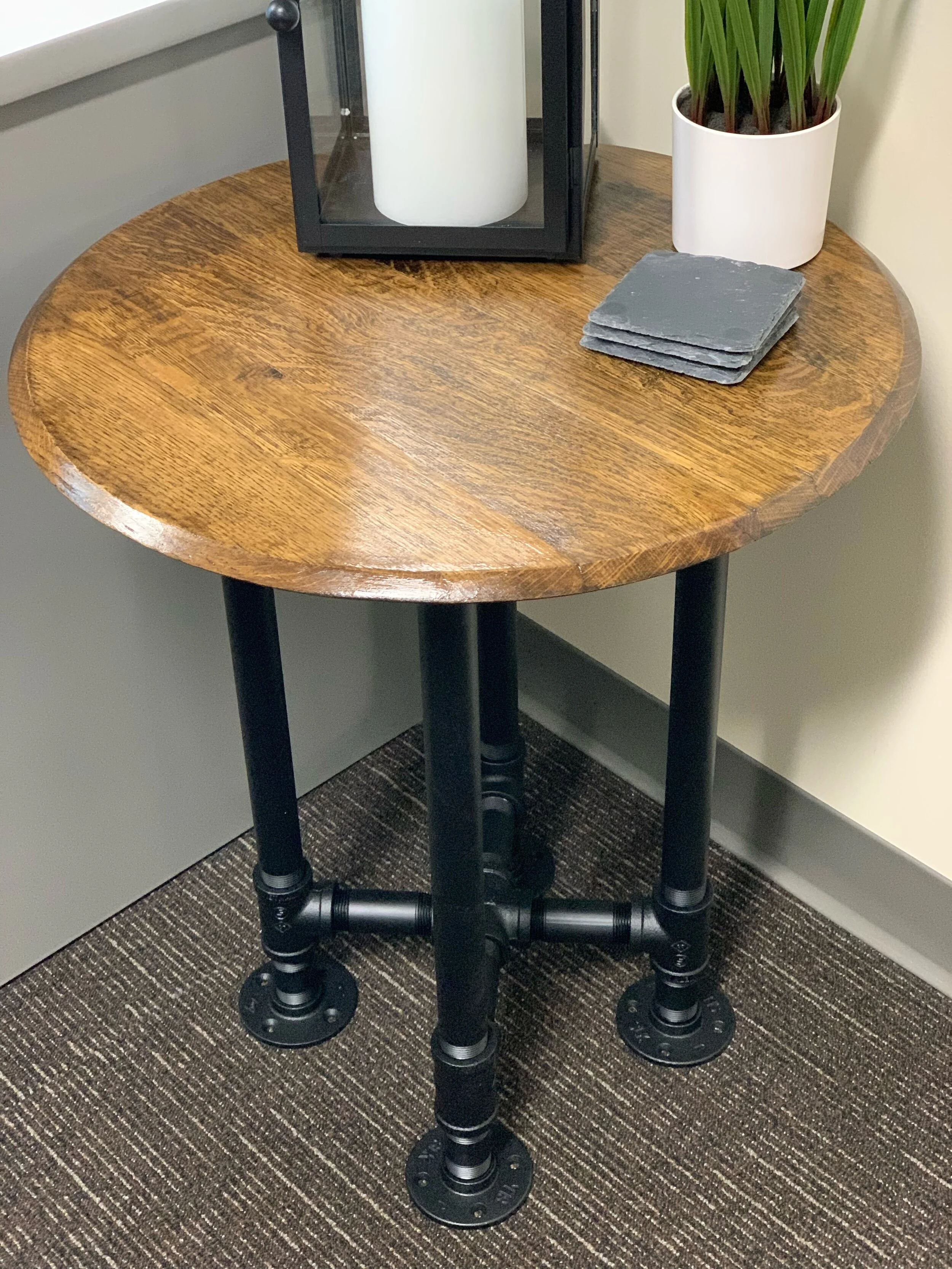 Old World Company - Bourbon whiskey barrel head end table with black gas pipe legs. 