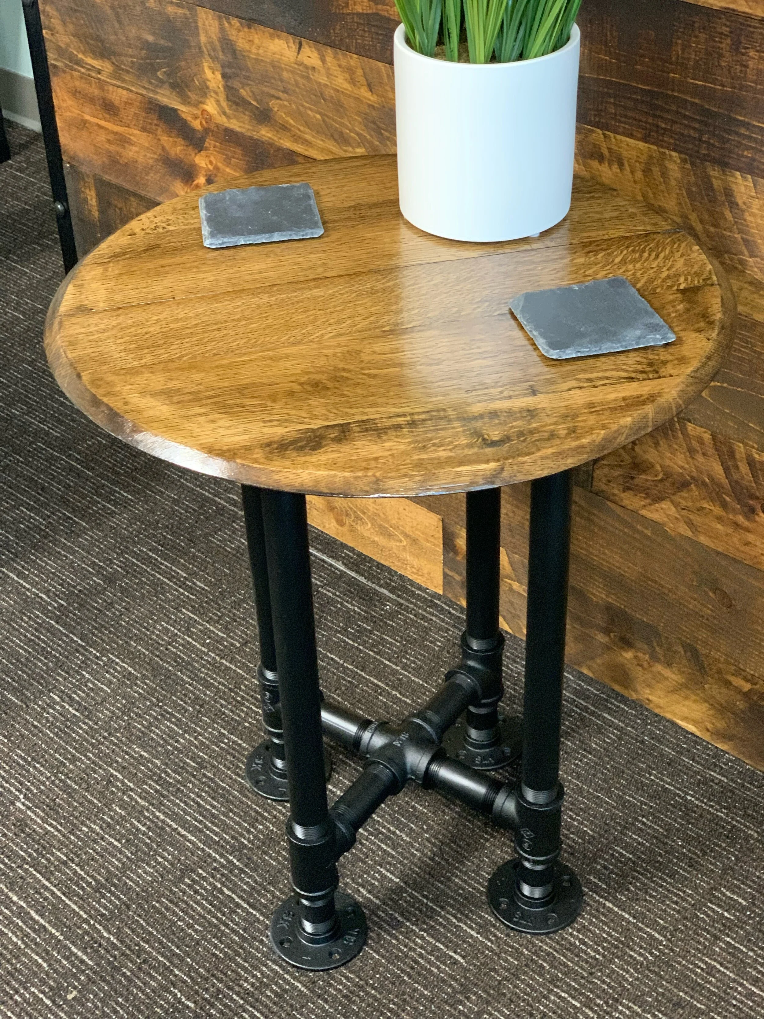 Old World Company - Bourbon whiskey barrel head end table with black gas pipe legs. 