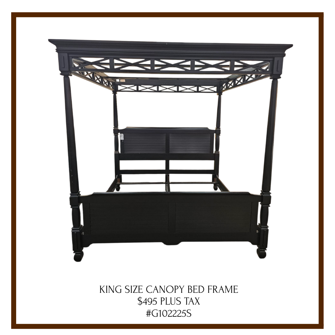 Black king size canopy bed frame with intricate lattice design on the canopy and a slatted back panel.