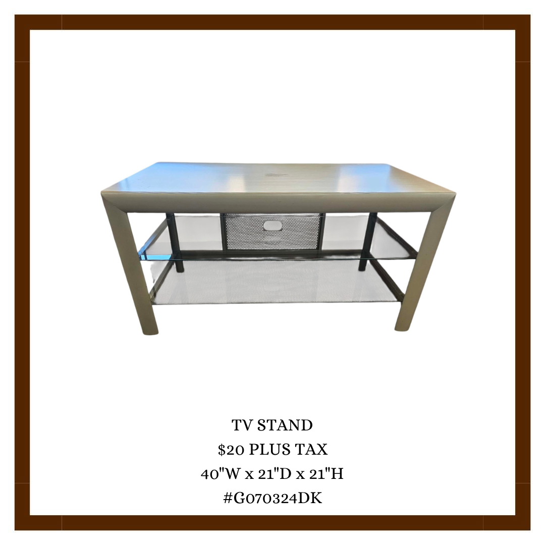 A metal TV stand with a top surface and a lower mesh shelf, with black metal supports and a ventilation cutout in the back panel.