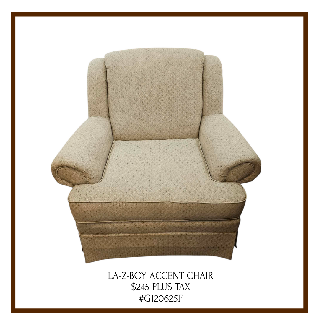 A beige upholstered armchair with a high back, rolled arms, and a skirted bottom. Text below indicates it is a 'LA-Z-BOY Accent Chair' priced at $245 plus tax.